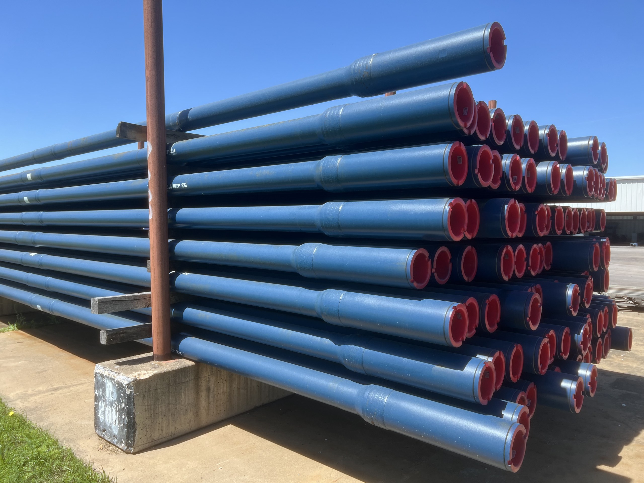 TSC heavy weight drill pipe racked in the yard, box ends toward the camera, showing the tool joints, tapers and center upsets.