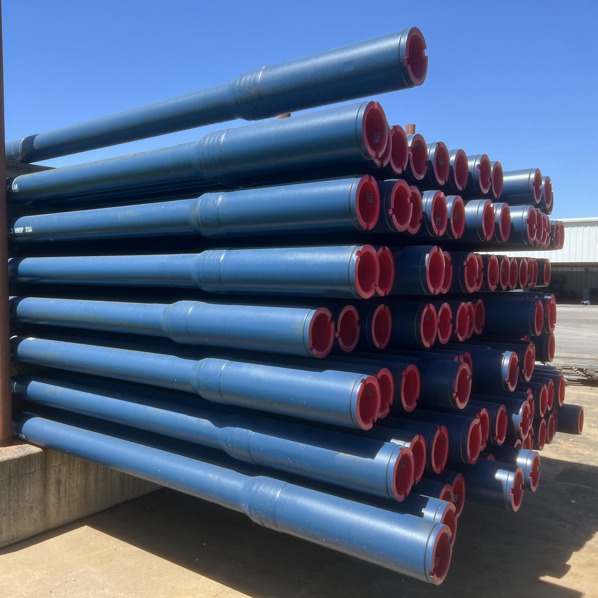 TSC heavy weight drill pipe racked in the yard, box ends toward the camera.